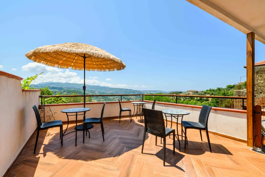 La terrazza di Ca' del Borgo con ombrellone e vista sulle colline