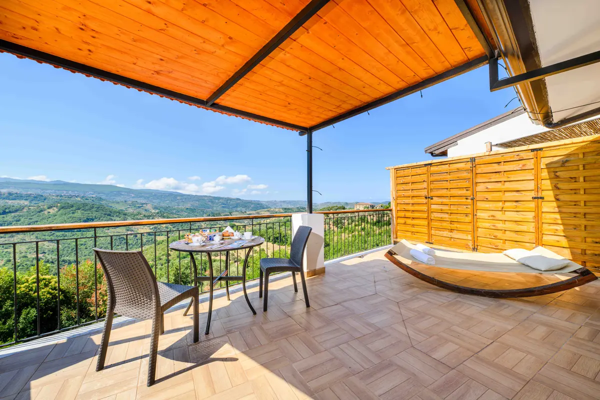 Terrazza coperta con tavolino, amaca e vista sulle colline